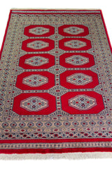 Alfombra Persa Yamouth rojo de 1.25 x 1.90 mts, vista en perspectiva del campo y las guardas; el diseño muestra dos columnas de medallones claros sobre un campo rojo y un borde geométrico oscuro