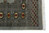 Alfombra Persa Bukara Yamouth celeste de 1.25 x 1.90 mts, detalle de guarda, borde y textura; el diseño muestra medallones ovalados y pequeños acentos geométricos sobre un campo celeste grisáceo