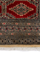 Alfombra Persa Yamouth beige y rojo de 1.20 x 1.97 mts, detalle de guarda, borde y textura; el diseño muestra medallones romboidales rojos enlazados sobre un campo beige y guardas oscuras
