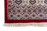 Alfombra Persa Yamouth rojo de 1.27 x 1.88 mts, detalle cercano de motivos y terminación; el diseño muestra una trama romboidal roja continua sobre un campo claro y un borde rojo definido
