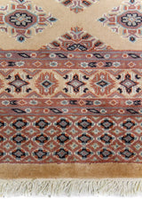 Alfombra Persa Yamouth beige de 1.27 x 1.78 mts, detalle de guarda, borde y textura; el diseño muestra pequeños motivos romboidales repetidos sobre un campo beige y guardas cálidas