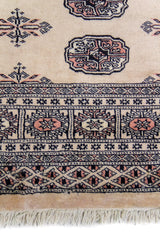 Alfombra Persa Bukara Yamouth beige de 1.37 x 1.83 mts, detalle de guarda, borde y textura; el diseño muestra medallones ovalados oscuros sobre un campo beige con múltiples guardas geométricas