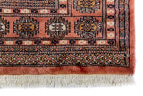 Alfombra Persa Bukara Yamouth rosado de 1.27 x 1.68 mts, detalle de guarda, borde y textura; el diseño muestra medallones ovalados repetidos sobre un campo rosado y un marco geométrico oscuro