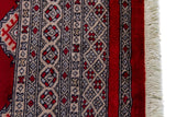 Alfombra Persa Yamouth rojo de 1.27 x 1.88 mts, detalle de guarda, borde y textura; el diseño muestra una retícula de rombos rojos enlazados con guardas geométricas de alto contraste