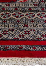 Alfombra Persa Yamouth rojo de 1.27 x 1.88 mts, detalle cercano de motivos y terminación; el diseño muestra una retícula de rombos rojos enlazados con guardas geométricas de alto contraste
