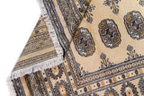 Alfombra Persa Bukara Yamouth beige de 1.27 x 1.86 mts, detalle de guarda, borde y textura; el diseño muestra medallones ovalados oscuros sobre un campo beige y un marco geométrico bien definido