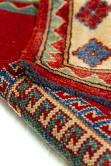 Alfombra Caucasica Kazak rojo y beige de 1.17 x 1.58 mts, detalle cercano de motivos y terminación; el diseño muestra tres grandes medallones geométricos sobre un campo rojo y guardas claras con pequeños acentos