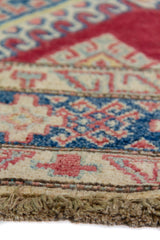 Alfombra Caucasica Kazak rojo y beige de 1.17 x 1.47 mts, detalle cercano de motivos y terminación; el diseño muestra medallones romboidales apilados sobre un campo rojo con amplias guardas beige