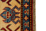Alfombra Caucasica Kazak rojo con detalles multicolor de 1.17 x 1.63 mts, vista en perspectiva del campo y las guardas; el diseño muestra motivos geométricos estilizados sobre un campo rojo y un marco claro con múltiples acentos