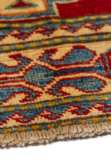 Alfombra Caucasica Kazak ladrillo y beige de 1.09 x 1.58 mts, detalle de guarda, borde y textura; el diseño muestra medallones geométricos escalonados sobre un campo ladrillo con guardas claras y pequeños acentos