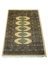 Alfombra Persa Yamouth verde y beige de 0.76 x 1.14 mts, vista en perspectiva del campo y las guardas; el diseño muestra una cadena central de grandes rombos beige sobre un campo verde oscuro con guardas geométricas