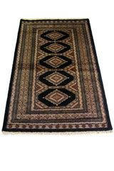 Alfombra Persa Bukara negro y gris de 1.52 x 0.94 mts, detalle cercano de los motivos del campo y la combinación de tonos