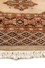 Alfombra Persa Bukara blanco y beige de 0.92 x 1.55 mts, detalle cercano de los motivos del campo y la combinación de tonos