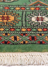 Alfombra Persa Bukara verde oscuro de 0.97 x 1.55 mts, detalle de guarda, trama visual y terminación de borde