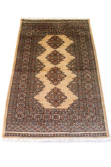Alfombra Persa Bukara beige y gris de 0.95 x 1.55 mts, vista en perspectiva que permite apreciar el campo central y las guardas