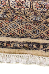Alfombra Persa Bukara beige y gris de 0.95 x 1.55 mts, detalle cercano de los motivos del campo y la combinación de tonos