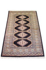 Alfombra Persa Bukara negro y beige de 0.94 x 1.52 mts, vista en perspectiva que permite apreciar el campo central y las guardas