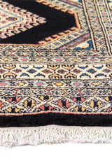 Alfombra Persa Bukara negro y beige de 0.94 x 1.52 mts, detalle de guarda, trama visual y terminación de borde