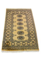 Alfombra Persa Bukara mostaza y beige de 0.76 x 1.27 mts, vista en perspectiva que permite apreciar el campo central y las guardas