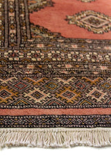 Alfombra Persa Bukara rosado y gris de 0.94 x 1.60 mts, detalle de guarda, trama visual y terminación de borde