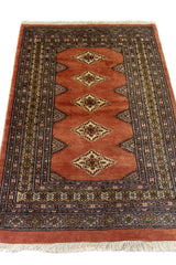 Alfombra Persa Bukara marrón y gris de 0.92 x 1.42 mts, detalle cercano de los motivos del campo y la combinación de tonos