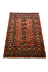 Alfombra Persa Bukara marrón de 0.81 x 1.22 mts, detalle de guarda, trama visual y terminación de borde