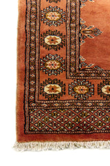 Alfombra Persa Bukara marrón de 0.81 x 1.22 mts, detalle cercano de los motivos del campo y la combinación de tonos
