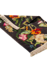 Alfombra Kilim verde de 0.60 x 0.90 mts, detalle cercano de los motivos del campo y la combinación de tonos
