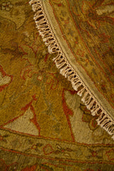 Detalle de alfombra redonda doblada con textura tejida, diseño floral y flecos artesanales.