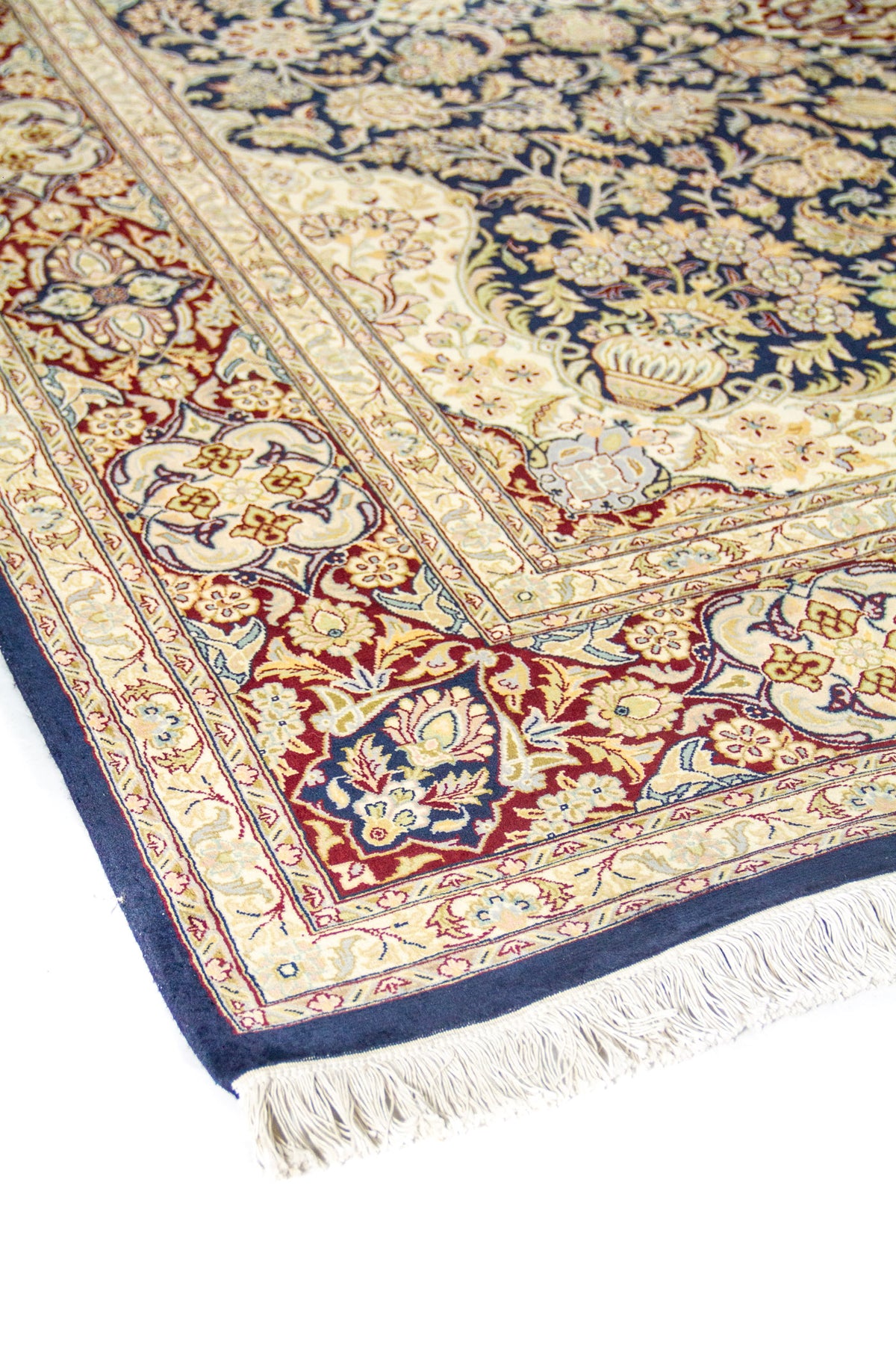 Detalle en ángulo del borde beige y rojo con flores, campo azul marino con diseño ornamental