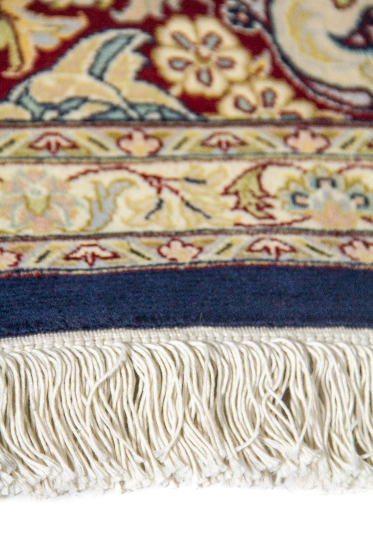 Detalle del medallón central sobre fondo azul marino y guarda decorativa en tonos beige y rojo