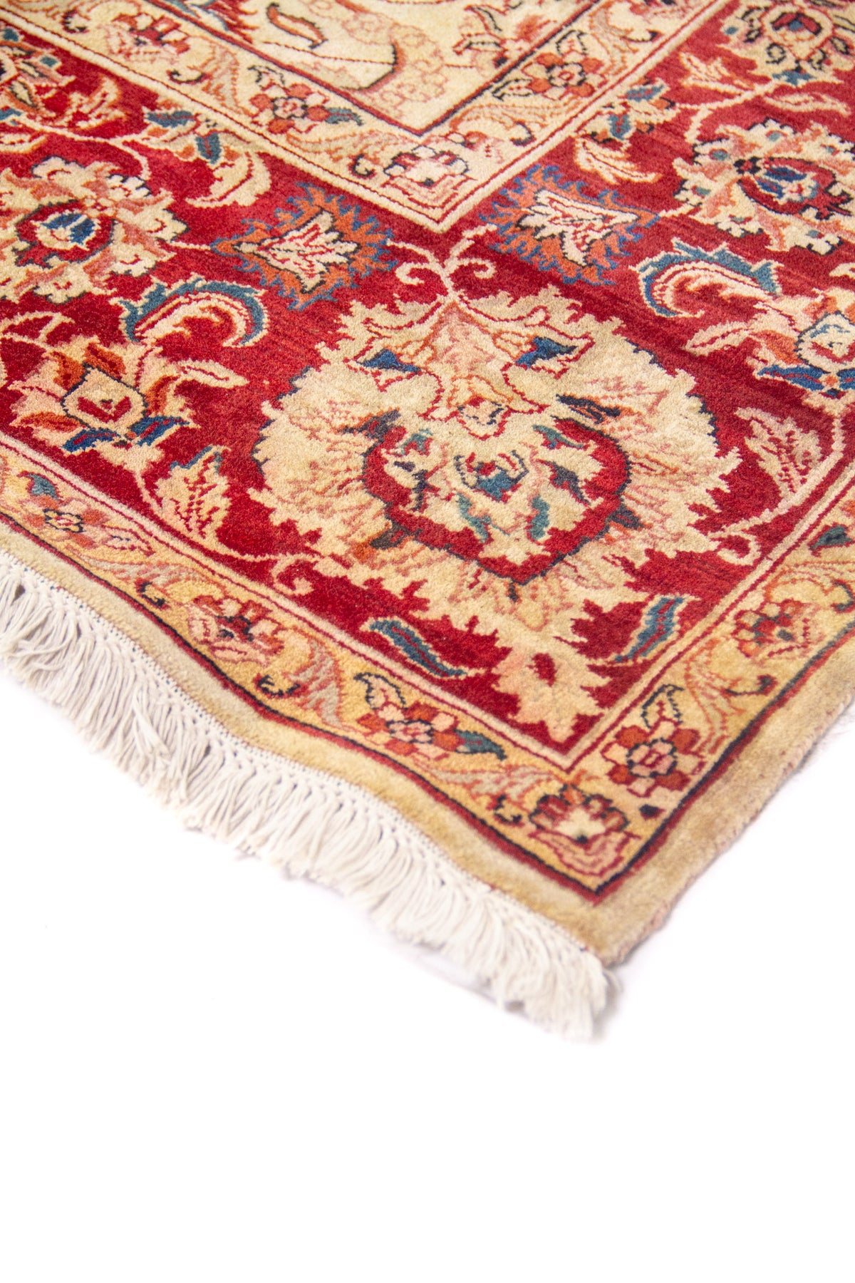 Detalle en perspectiva del borde: guarda roja con flores y franja clara con arabesco.