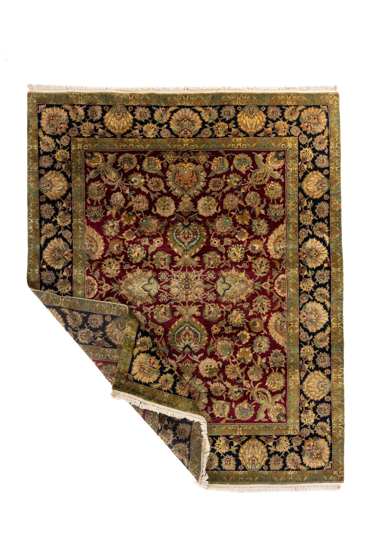 Alfombra floral roja y negra con una esquina doblada que deja ver el reverso y los flecos