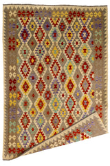 Vista general de alfombra kilim con una esquina doblada, mostrando el reverso del tejido y su carácter reversible.