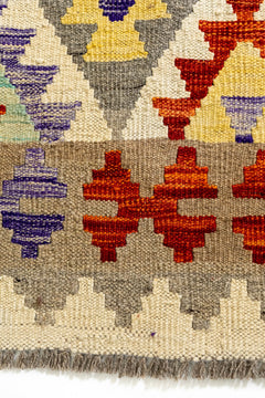 Primer plano del borde inferior derecho con figuras geométricas rojo y morado sobre fondo marrón grisáceo.