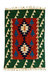 Vista completa de una alfombra kilim con fondo rojo y verde, decorada con figuras de triángulos en tonos crema y azul, formando un patrón central simétrico.