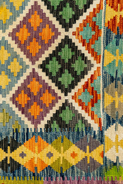 Detalle del borde inferior derecho con rombos de colores contrastantes, incluyendo verde, naranja y azul, sobre fondo claro.