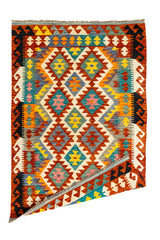 Imagen de la alfombra kilim con una esquina doblada, mostrando el reverso del tejido y su estructura reversible tradicional.