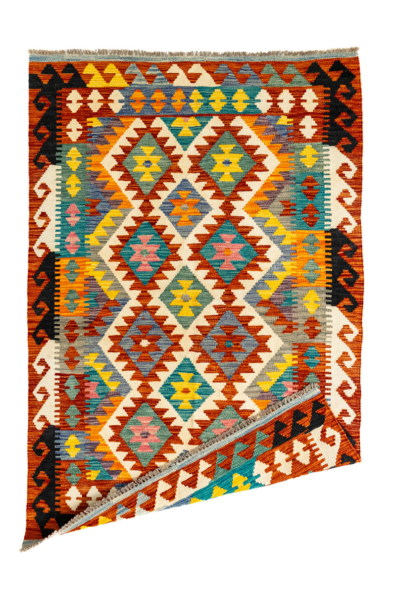 Imagen de la alfombra kilim con una esquina doblada, mostrando el reverso del tejido y su estructura reversible tradicional.