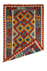 Alfombra kilim con una esquina doblada, mostrando el reverso del tejido y su diseño artesanal.
