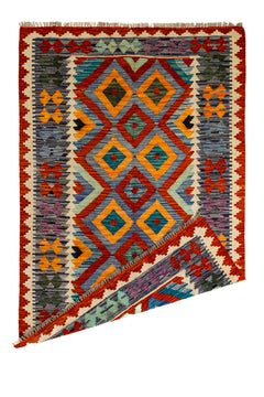 Alfombra kilim con una esquina doblada, mostrando el reverso del tejido y su diseño artesanal.