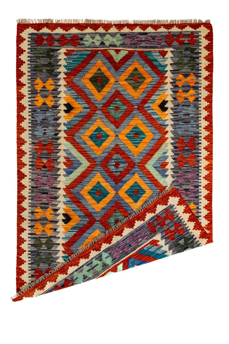 Alfombra kilim con una esquina doblada, mostrando el reverso del tejido y su diseño artesanal.