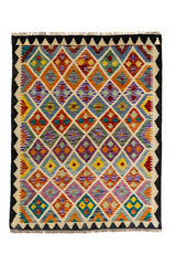 Vista completa de una alfombra kilim con patrón de diamantes multicolor y bordes en zigzag negro sobre fondo beige.