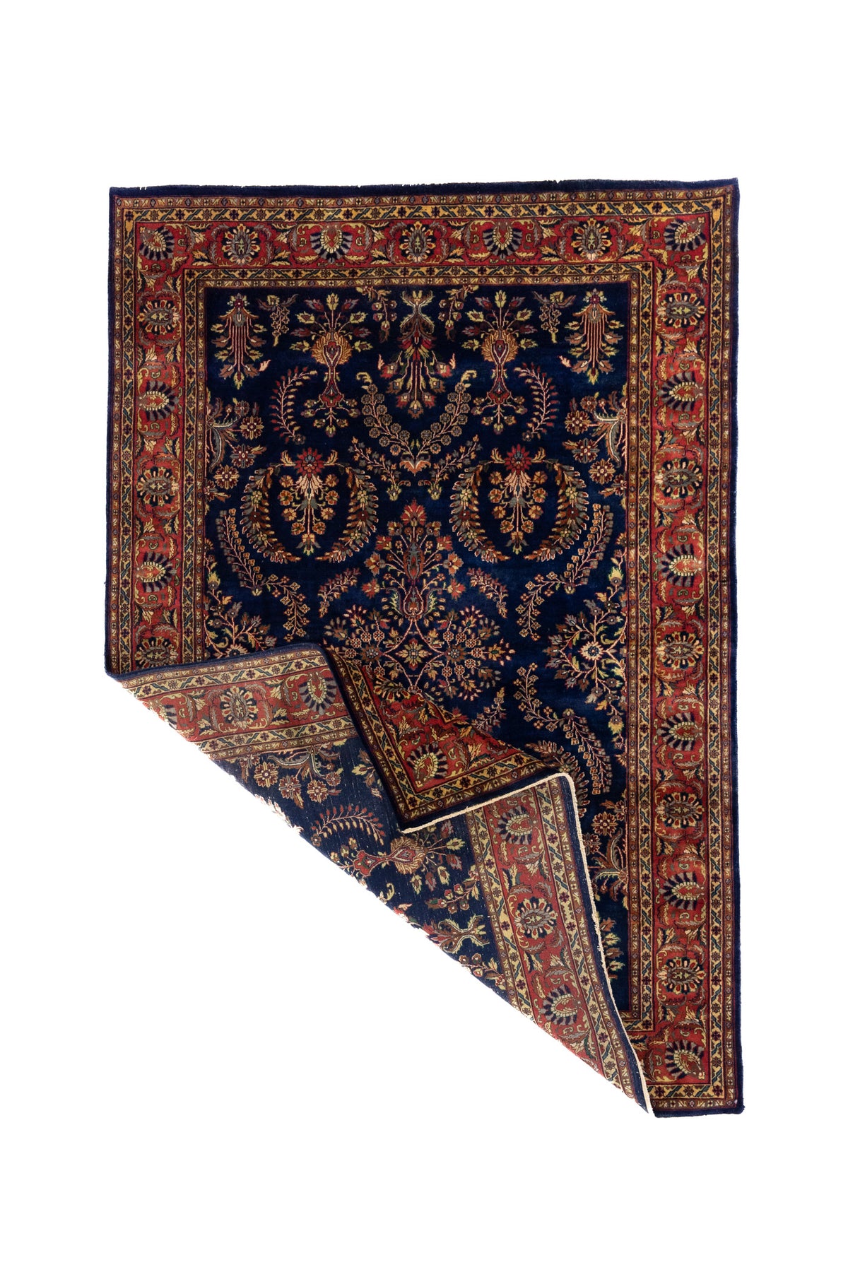 Alfombra azul de estilo oriental con una esquina levantada, mostrando el reverso y el grosor del tejido.