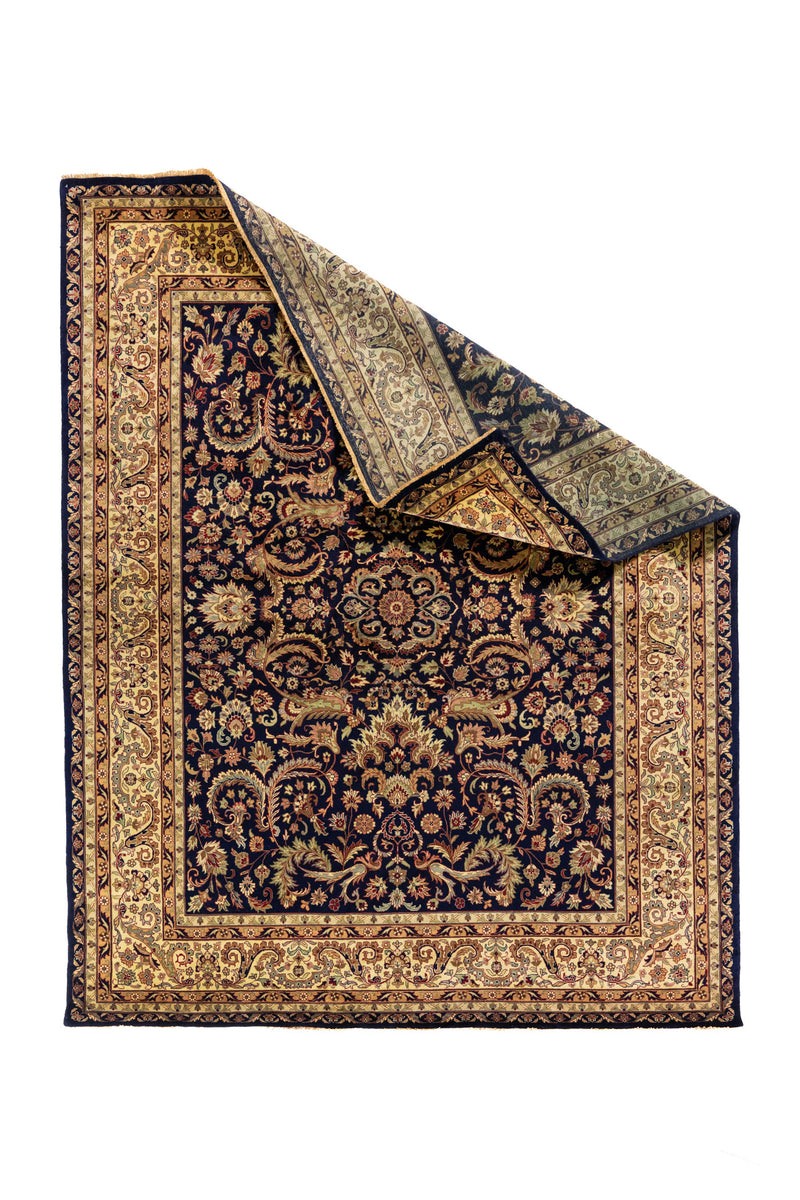 Alfombra oriental azul marino con esquina levantada que muestra el reverso y la estructura del tejido