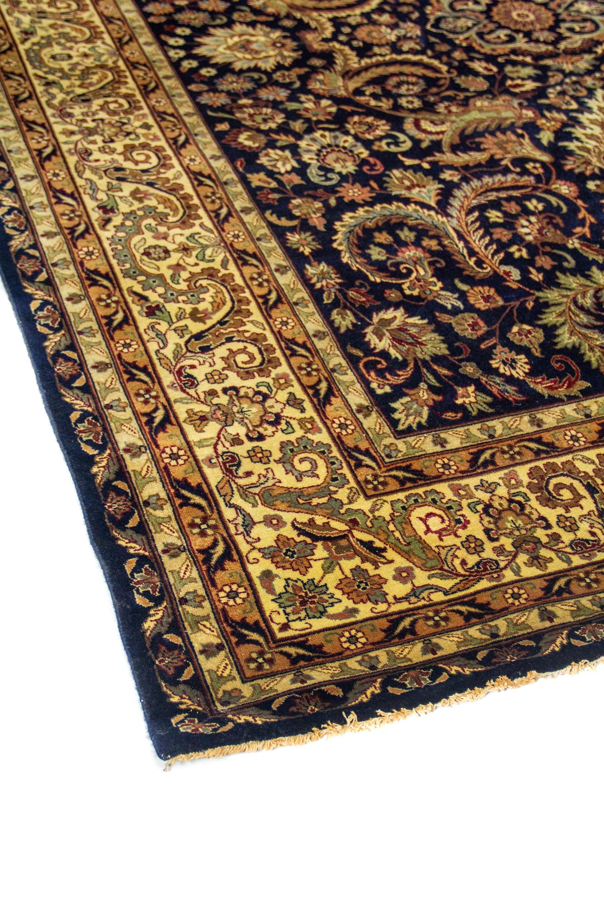 Detalle de esquina de alfombra azul con guarda beige decorada y patrón floral clásico