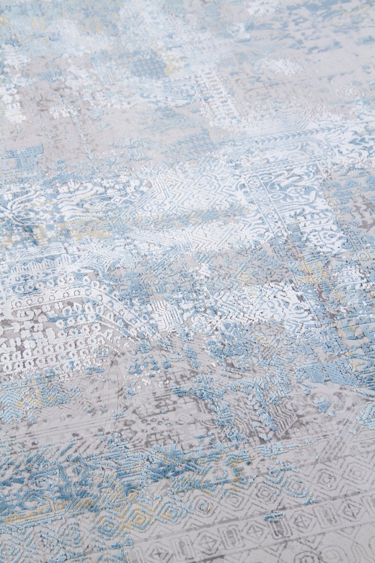 Detalle de textura de alfombra azul y gris con relieve y motivos geométricos desgastados