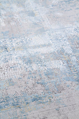 Detalle de textura de alfombra azul y gris con relieve y motivos geométricos desgastados
