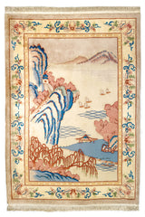 Alfombra oriental con paisaje montañoso, árboles rosados y detalles de agua en tonos suaves de azul y beige.