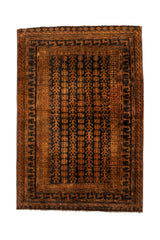 Alfombra oriental de tonos oscuros con patrón geométrico repetitivo y bordes múltiples en marrón y negro.